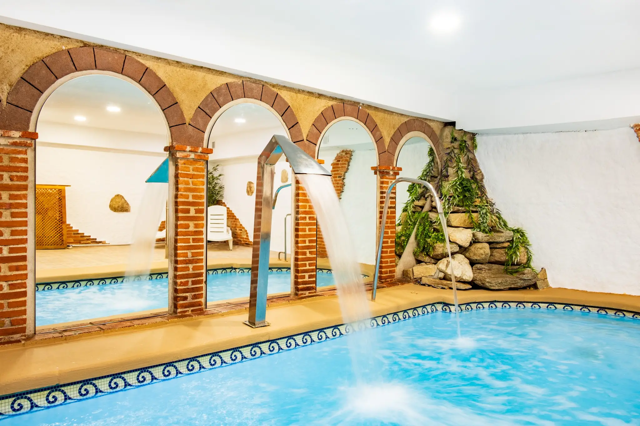 Piscina interior terminada con cascadas y zona de spa